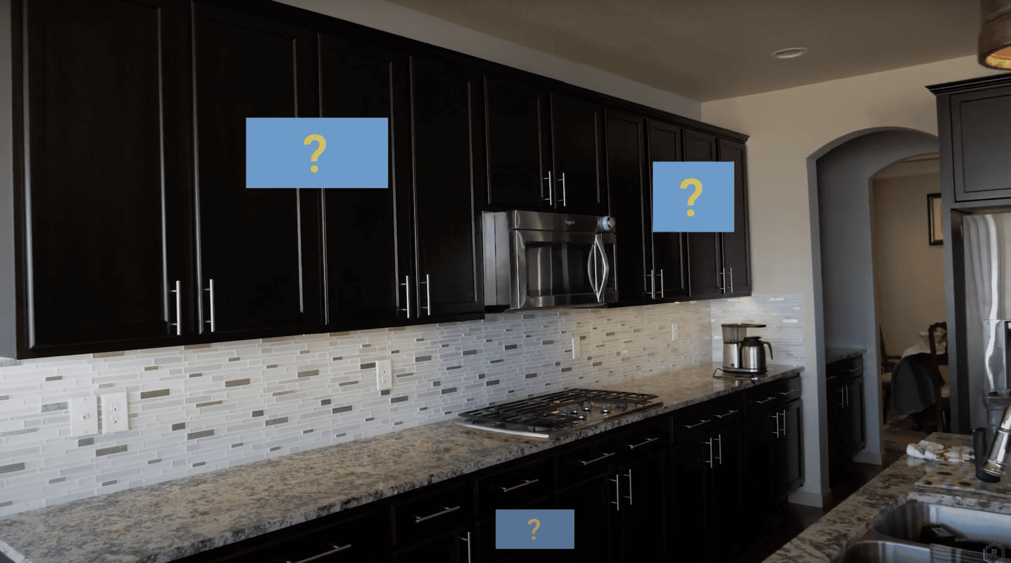 Image of black kitchen cabinets w/question marks on doors and drawers