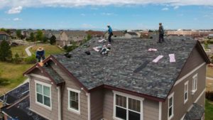 aerial shot of roofers redoing a roof
