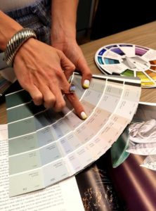 color consultant looking over color wheel and pointing at colors