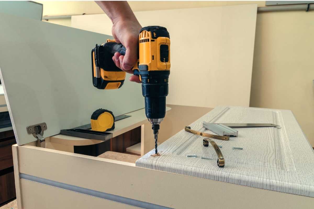 photo of someone drilling hardware into cabinetry