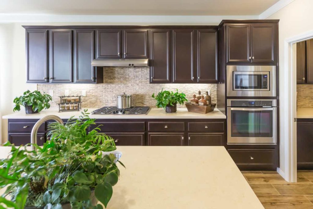 photo of a kitchen with dark brown cabinets and gray walls