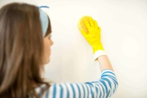 image of a woman cleaning her walls with a sponge