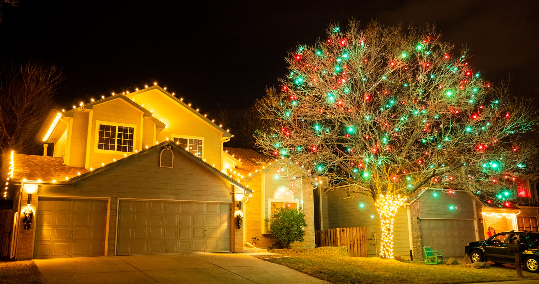 Photo of a professional holiday light installation of a tree with multi-color lights