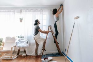 photo of a couple painting their walls