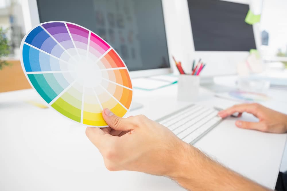 Hand holding color wheel while using computer