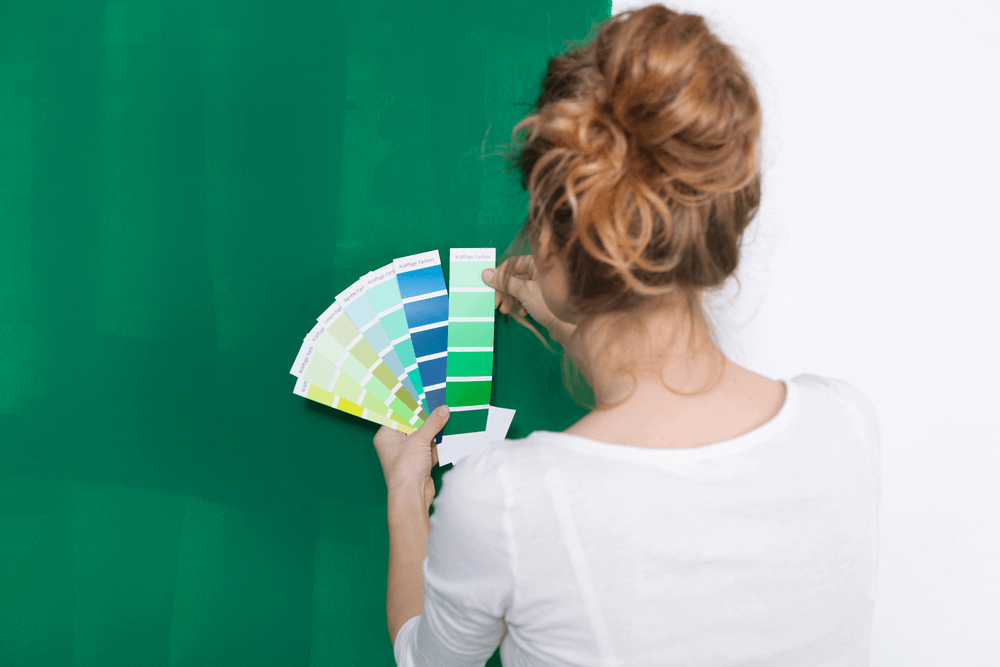 Woman with color plates in front of a green wall